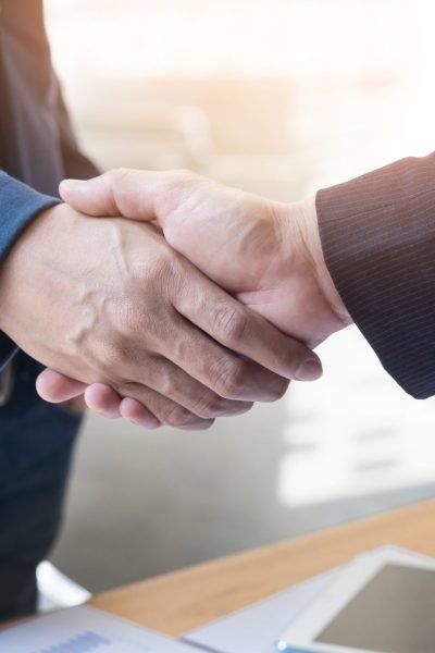 Two confident business man shaking hands during a meeting in the office, success, dealing, greeting and partner concept